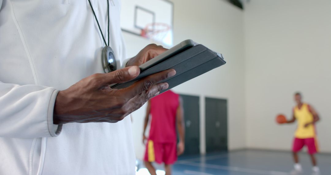 Basketball Coach Analyzing Game with Tablet Technology