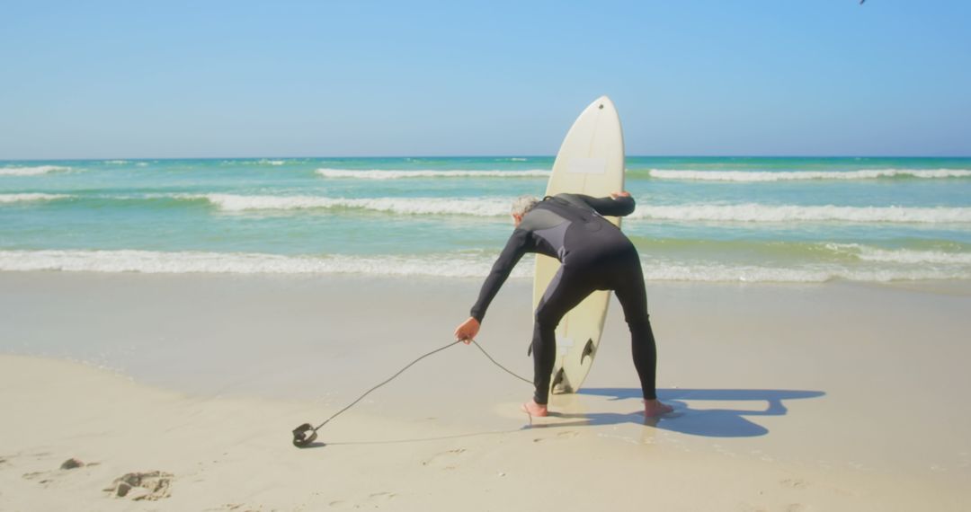 Senior Surfer with Surfboard Posing at Ocean Shoreline