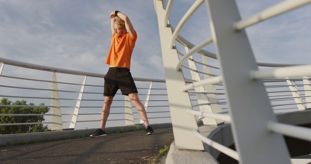 Man Stretching Arms on a Bridge During Morning Workout - Free Images, Stock Photos and Pictures on Pikwizard.com