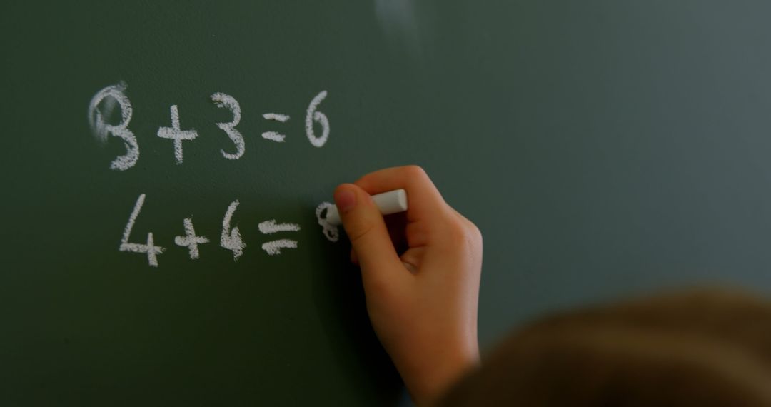 Child Writing Mathematical Equations on Chalkboard