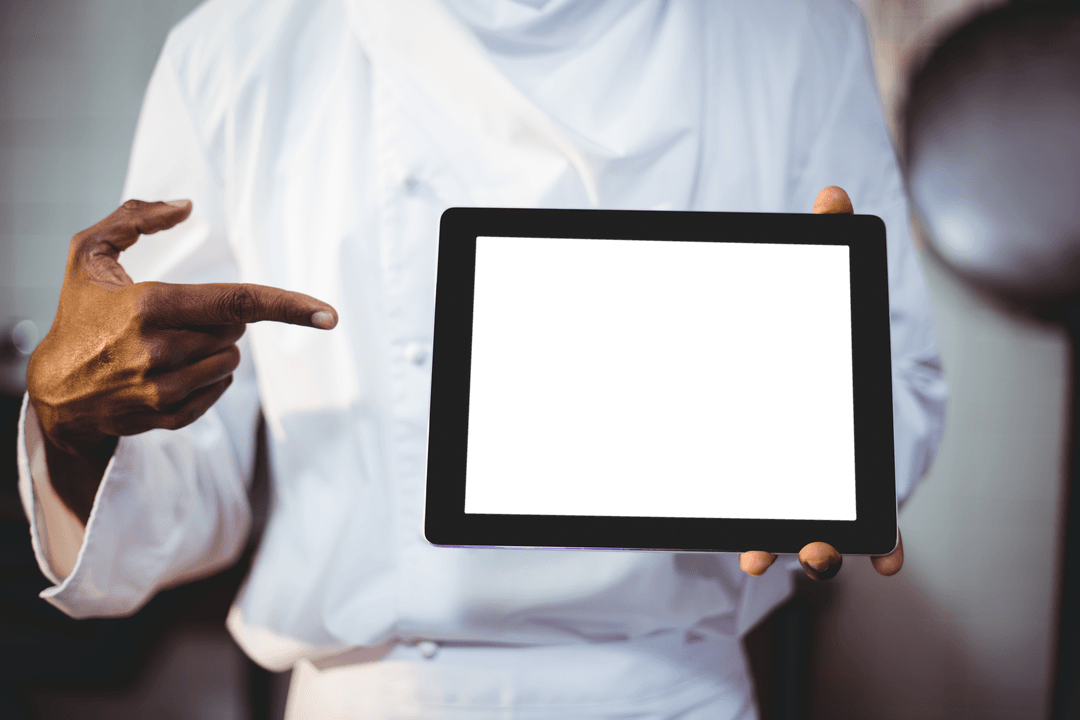 Chef Pointing at Transparent Tablet Screen in Kitchen