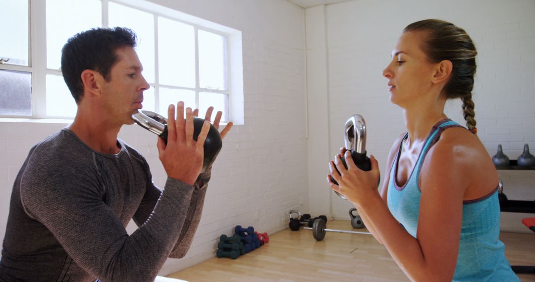 Man and Woman Exercising with Kettlebells in Gym - Free Images, Stock Photos and Pictures on Pikwizard.com