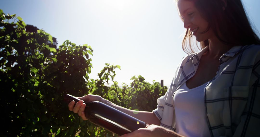 Woman Holding Wine Bottle in Vineyard at Sunset - Free Images, Stock Photos and Pictures on Pikwizard.com