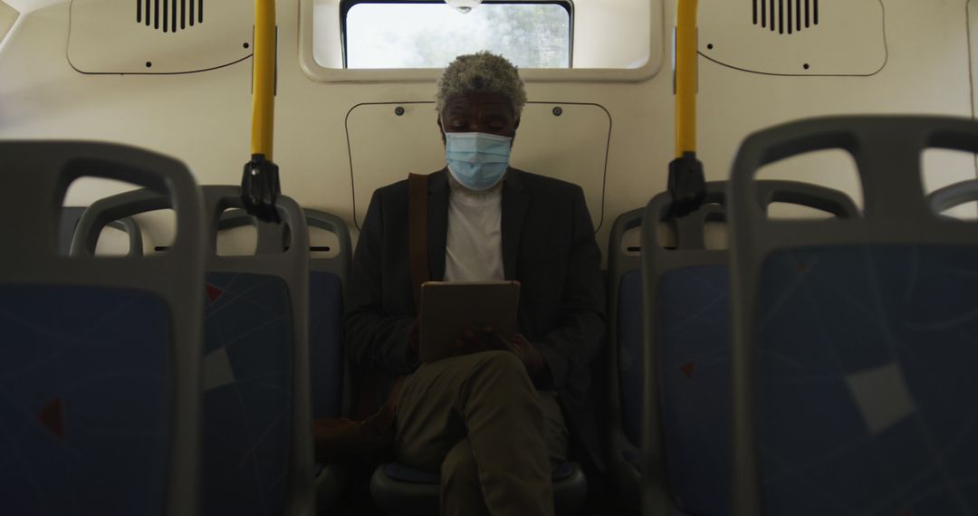 Elderly Man Wearing Mask Using Tablet on Public Bus - Free Images, Stock Photos and Pictures on Pikwizard.com