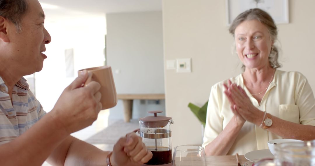 Smiling Elderly Couple Enjoying Coffee Together in Minimalist Home
