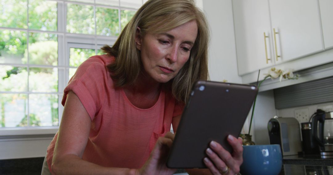 Senior Woman Using Tablet in Kitchen - Free Images, Stock Photos and Pictures on Pikwizard.com