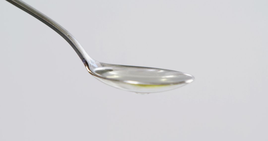 Close-up of Silver Spoon with Liquid on White Background - Free Images, Stock Photos and Pictures on Pikwizard.com