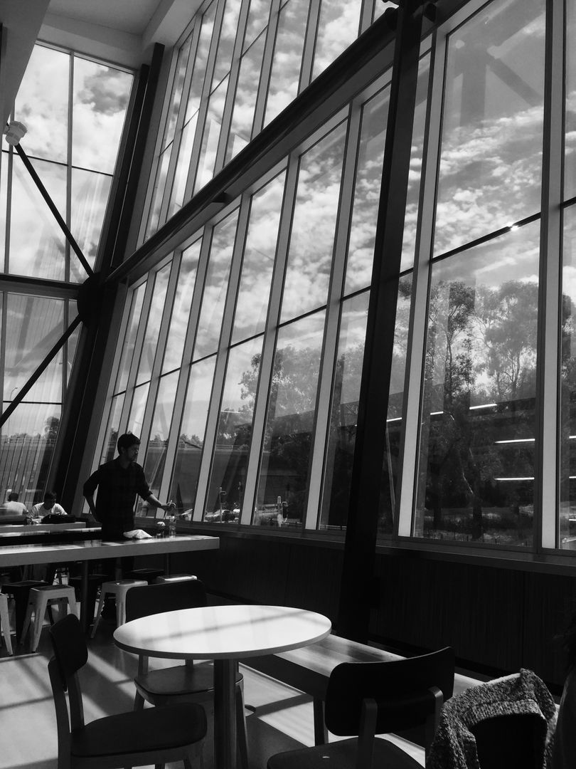 Man Standing in Modern Library with Large Glass Windows - Free Images, Stock Photos and Pictures on Pikwizard.com