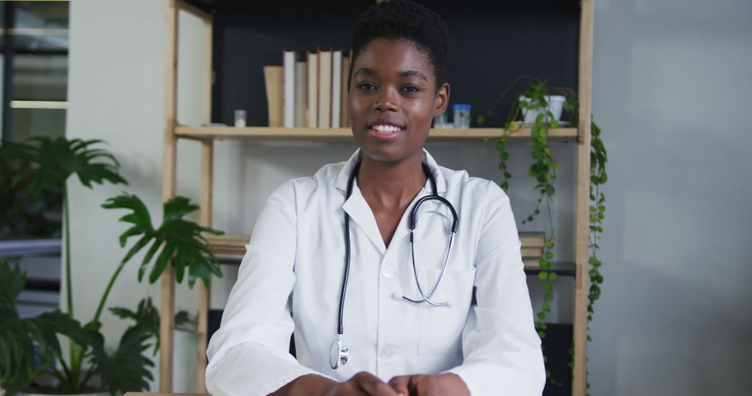 Confident African Female Doctor Sitting at Desk with Stethoscope - Free Images, Stock Photos and Pictures on Pikwizard.com