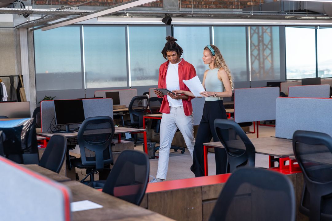 Diverse Coworkers Discussing Work in Modern Open-Plan Office