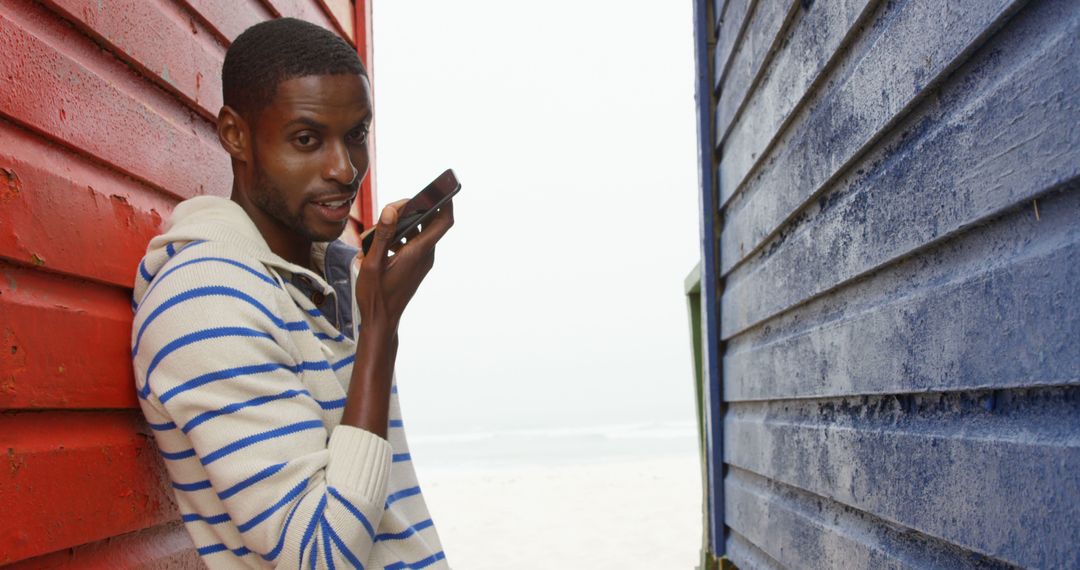 Man Using Smartphone in Alleyway by the Beach - Free Images, Stock Photos and Pictures on Pikwizard.com