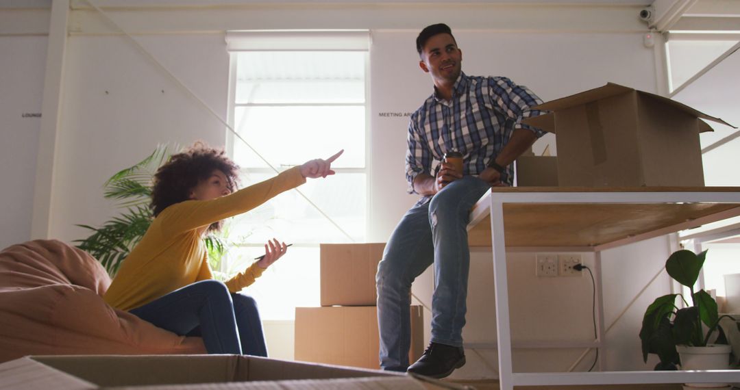 Cheerful Couple Unpacking Boxes in New Home with Sunlight