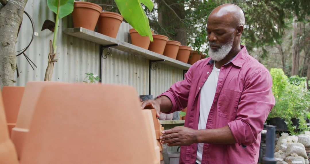 Man Arranging Plant Pots in Outdoor Garden Center - Free Images, Stock Photos and Pictures on Pikwizard.com