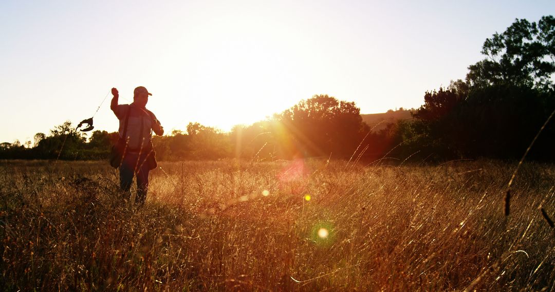 Silhouette of Person in Field During Golden Hour Sunrise or Sunset - Free Images, Stock Photos and Pictures on Pikwizard.com