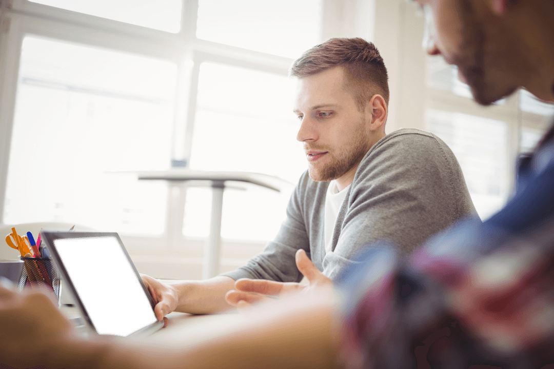 Two Colleagues Discussing Business Ideas with a Transparent Tablet in Office