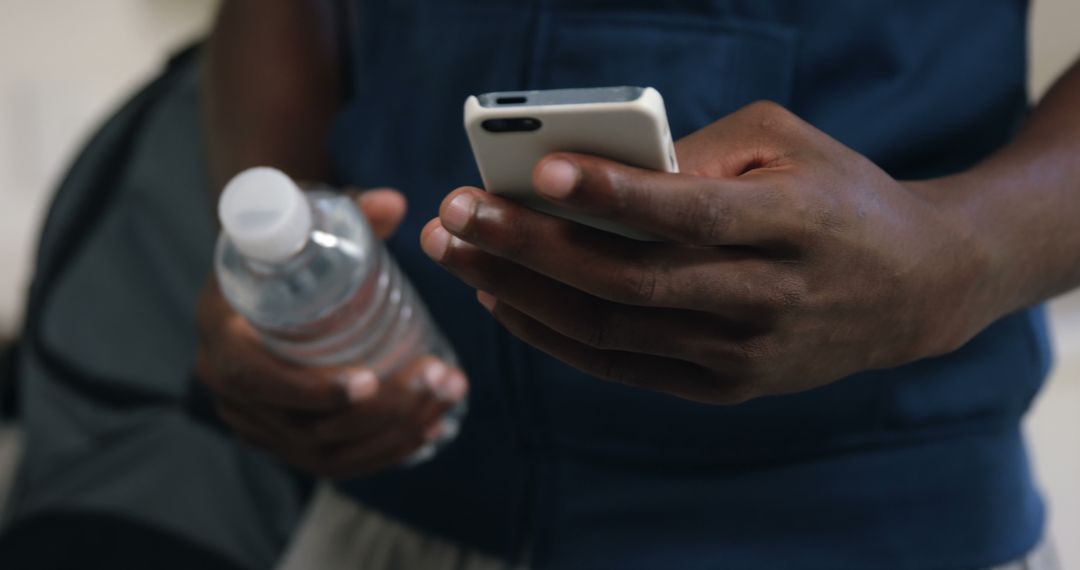 Person Holding Smartphone and Water Bottle - Free Images, Stock Photos and Pictures on Pikwizard.com