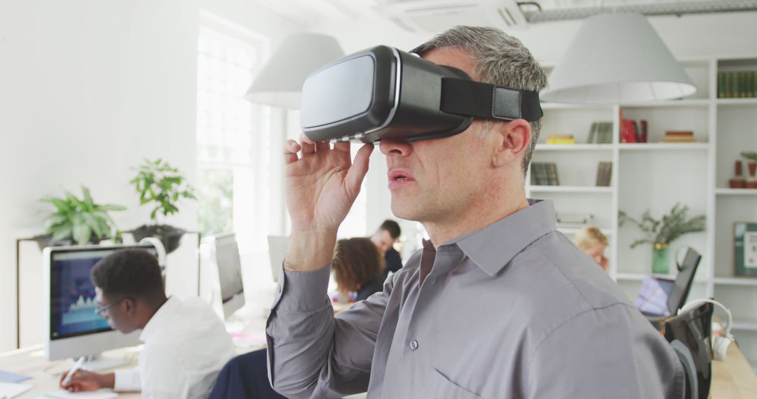 Professional man using virtual reality glasses in modern office environment - Free Images, Stock Photos and Pictures on Pikwizard.com