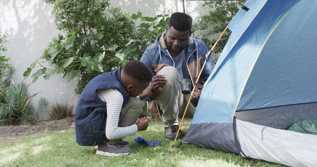 Father and Son Bonding While Setting Up Tent in Backyard
