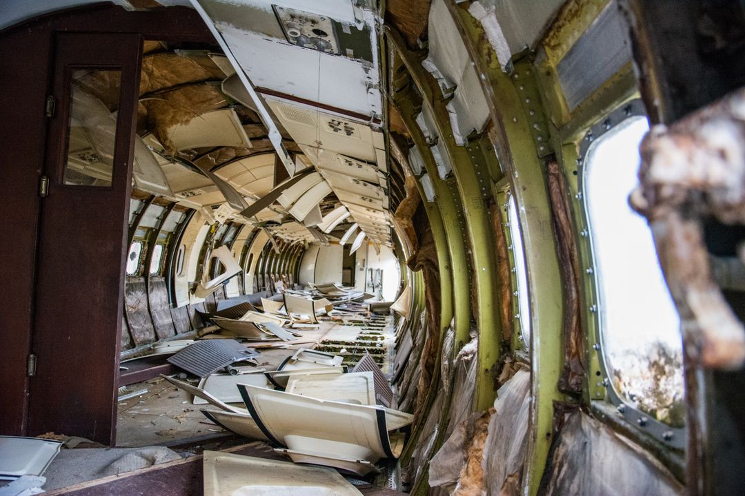 Abandoned plane crash interior with wreckage and debris