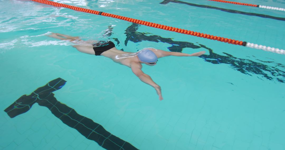 Professional Swimmer Focusing on Perfect Stroke in Indoor Pool - Free Images, Stock Photos and Pictures on Pikwizard.com