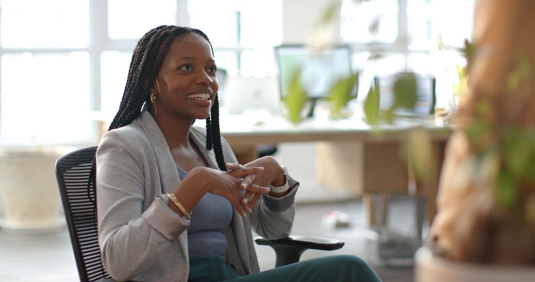 Smiling African American professional leading discussion in modern open-plan office