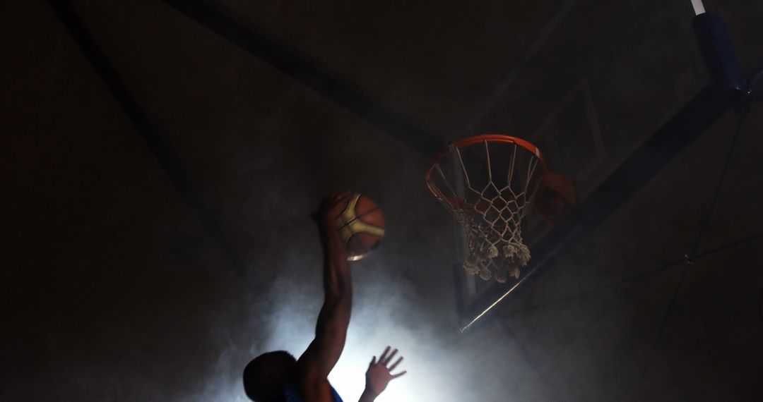 Basketball Player Executing Flawless Dunk Under Dramatic Lighting