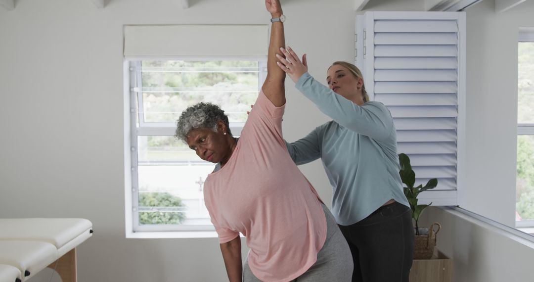 Physical Therapist Assisting Senior Woman in Shoulder Stretch Exercise - Free Images, Stock Photos and Pictures on Pikwizard.com