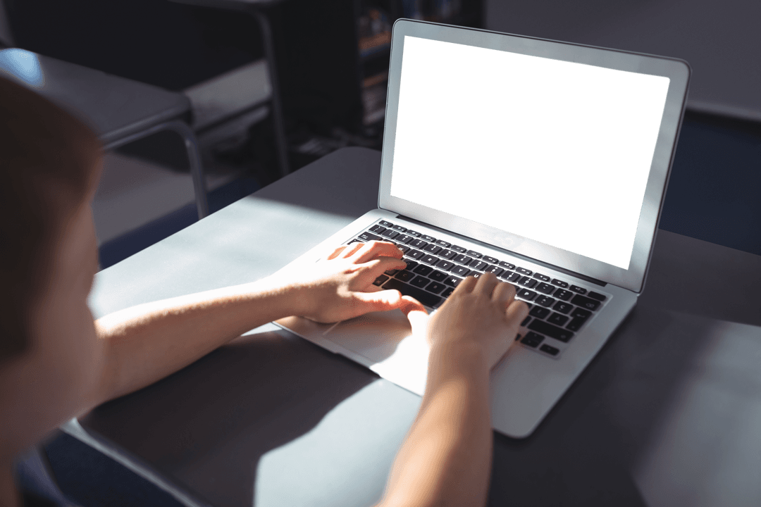 Boy Typing on Laptop with Transparent Screen in Classroom Setting