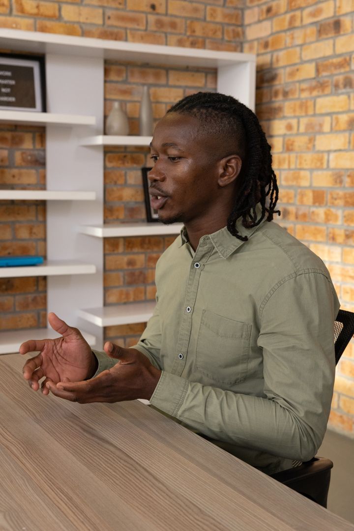 Man Engaging in Conversation at Loft-Style Office Desk