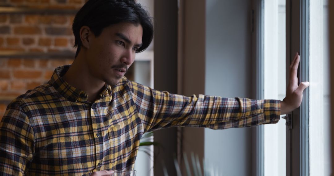 Contemplating Man Enjoying Coffee by Window at Home