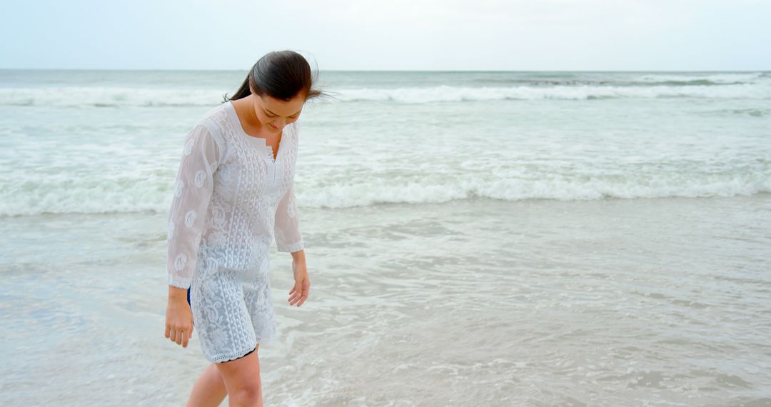 Young Woman Walking Along Seashore on Peaceful Beach - Free Images, Stock Photos and Pictures on Pikwizard.com