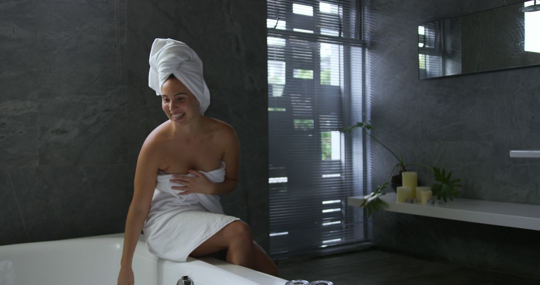 Smiling Woman in Towel Sitting on Bathtub in Modern Bathroom - Free Images, Stock Photos and Pictures on Pikwizard.com