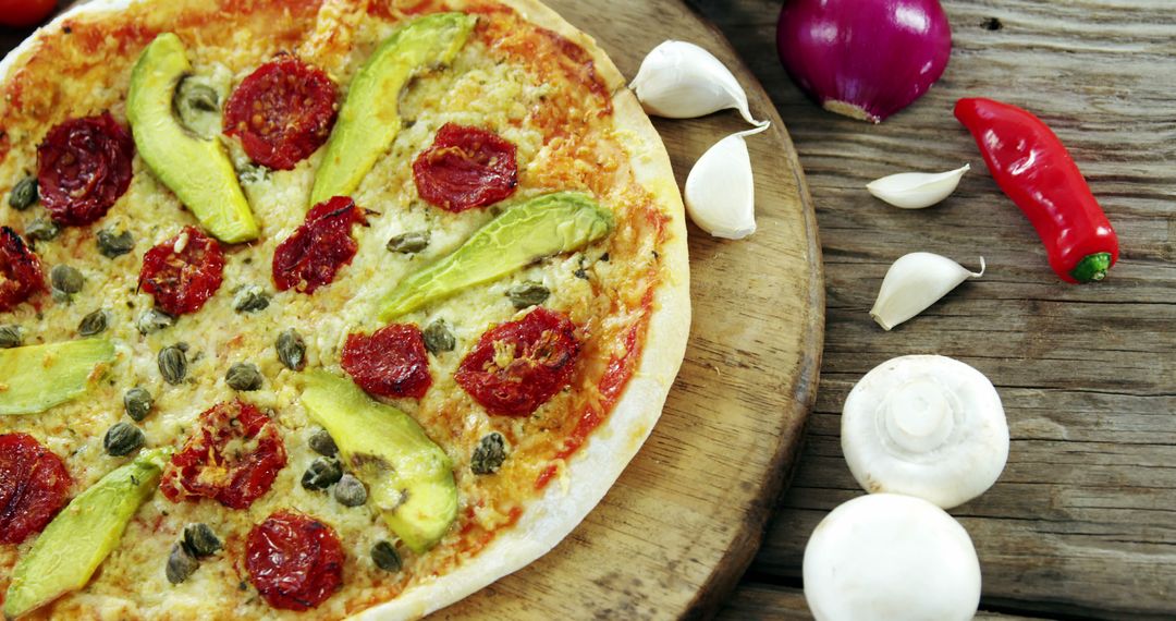 Vegetarian Pizza with Avocado, Tomato, and Capers on Rustic Wooden Table - Free Images, Stock Photos and Pictures on Pikwizard.com