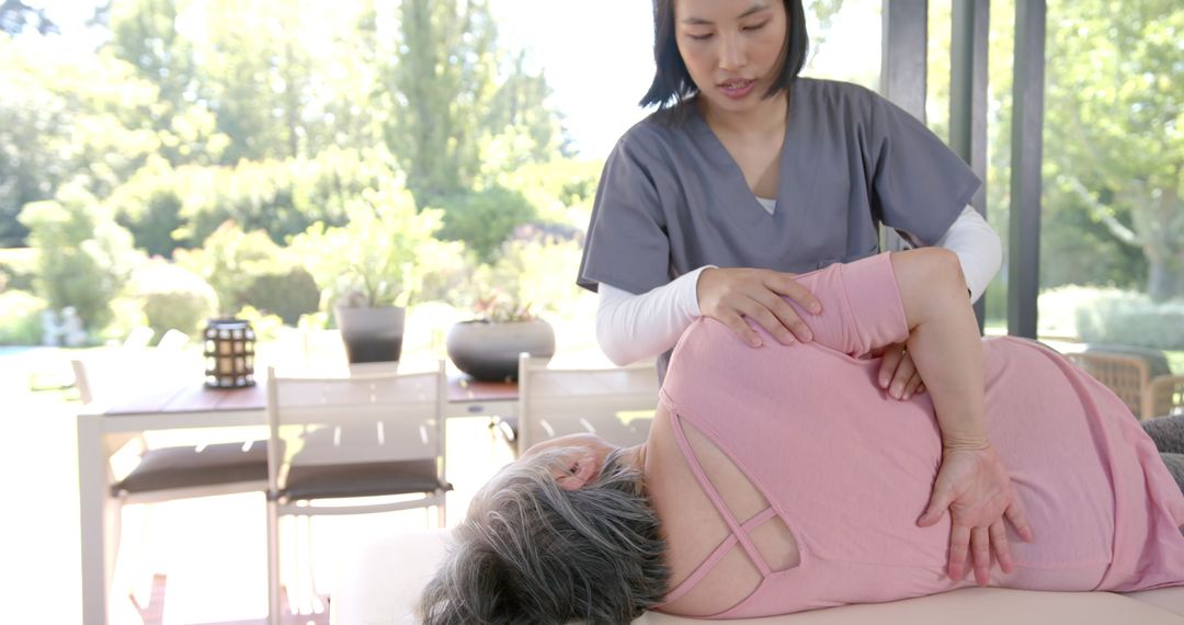 Physiotherapist Assisting Senior Woman with Stretching Exercise