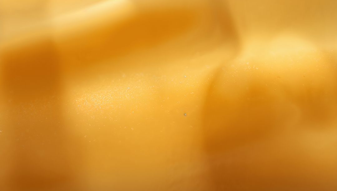 Macro Abstract Golden Texture Showing Smooth Speckled Surface and Shallow Ridges Glossy