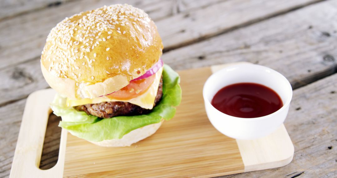 Delicious Cheeseburger on Wooden Board with Ketchup - Free Images, Stock Photos and Pictures on Pikwizard.com