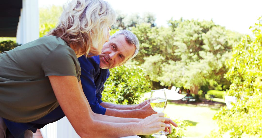 Senior Couple Enjoying Conversation with Wine on Balcony - Free Images, Stock Photos and Pictures on Pikwizard.com