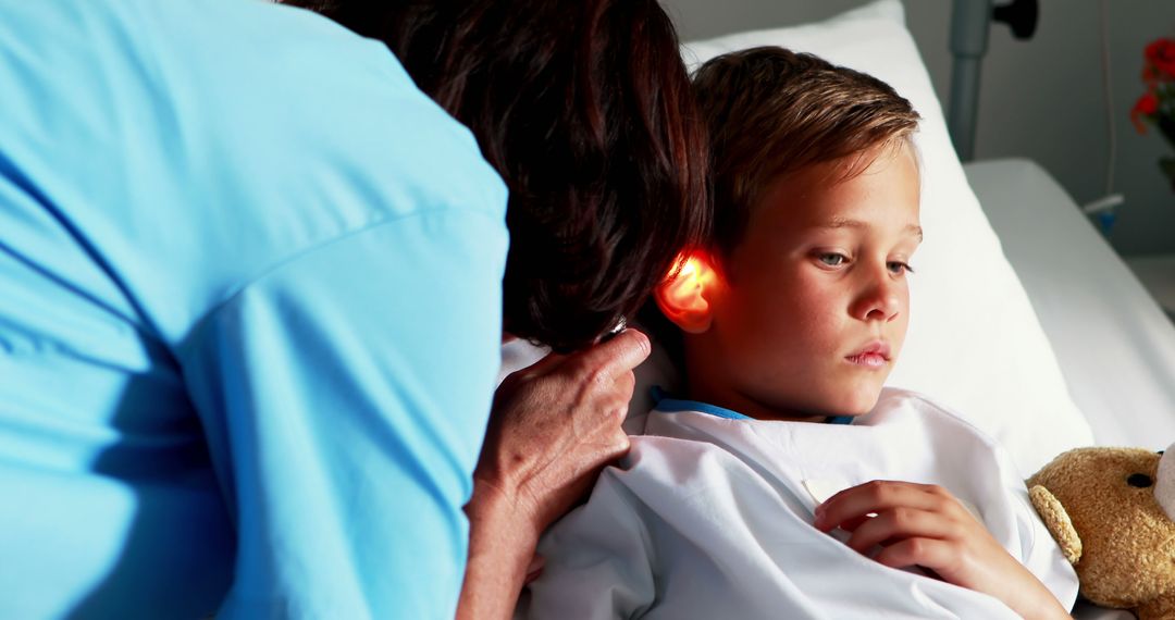 Doctor Examining Boy's Ear with Otoscope in Hospital Bed - Free Images, Stock Photos and Pictures on Pikwizard.com