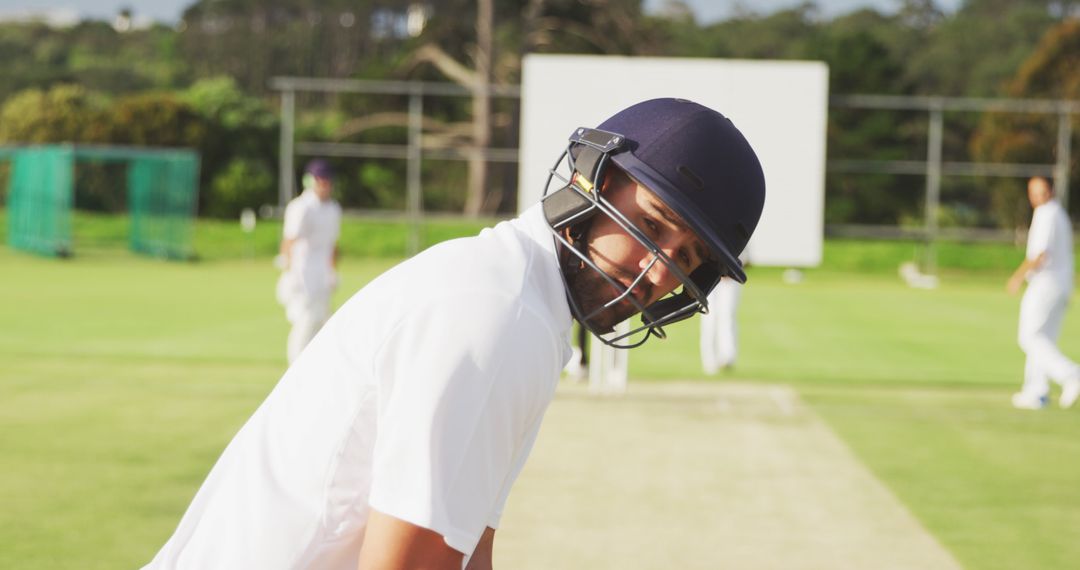 Focused Cricketer in Helmet Standing on Pitch During Match - Free Images, Stock Photos and Pictures on Pikwizard.com