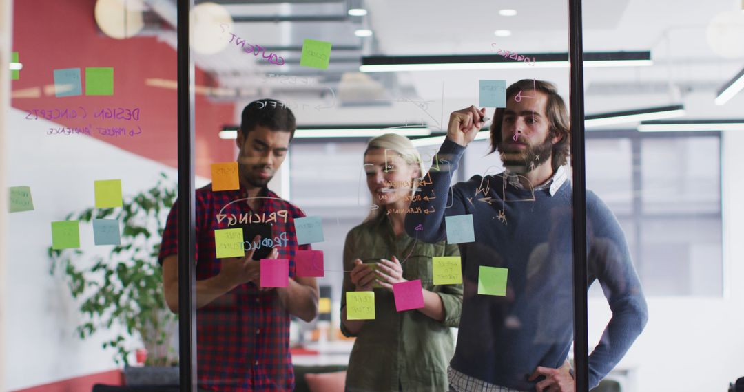 Team Discussing Ideas with Sticky Notes on Glass Board