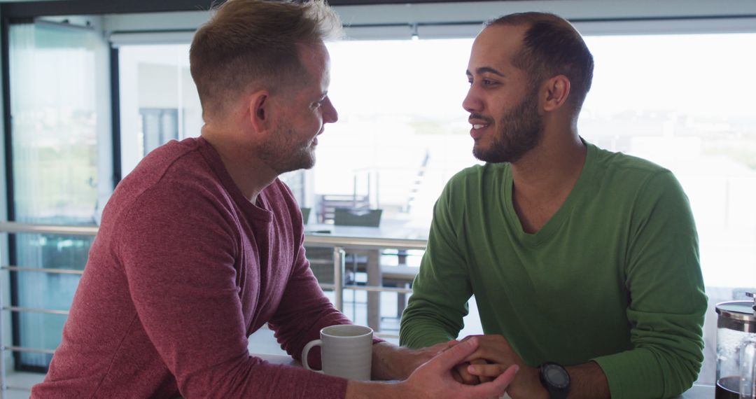 Loving Multicultural Couple Holding Hands in Kitchen
