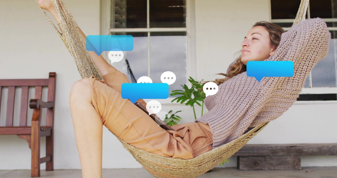 Reclining woman on hammock porch using tablet with floating chat bubbles and cozy sweater