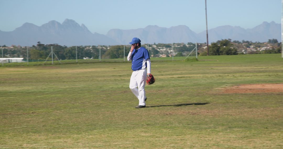 Baseball Player Strolling Across Sunlit Field