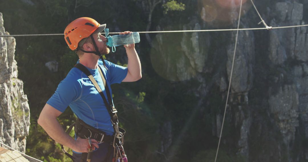 Man Hydrating While Rock Climbing with Safety Gear Outdoors - Free Images, Stock Photos and Pictures on Pikwizard.com