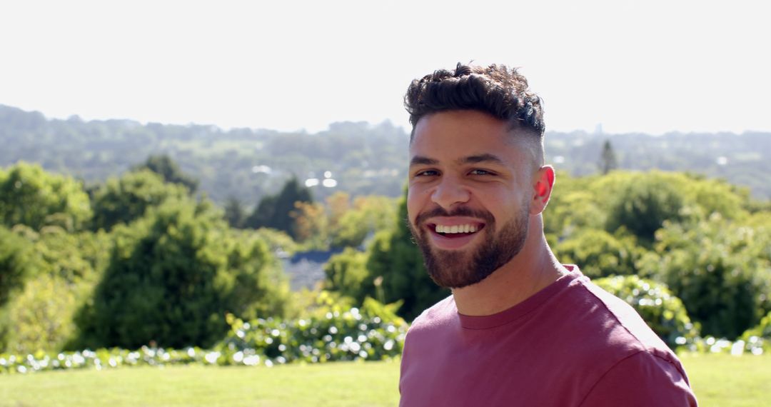 Smiling Man Enjoying Relaxation in Sunny Hillside View