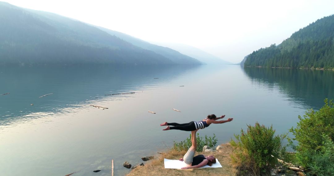 Couple Practicing Acro Yoga on Lakeside in Serene Mountain Landscape - Free Images, Stock Photos and Pictures on Pikwizard.com