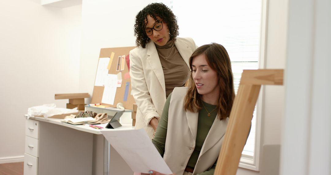 Creative team reviewing fabric samples and design plan in modern studio workspace