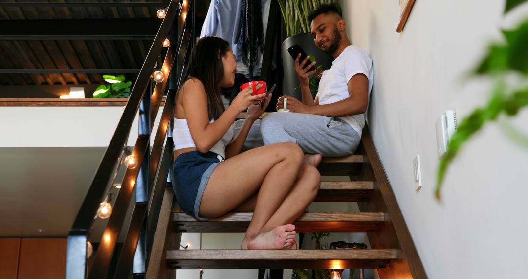 Young Couple Sitting on Staircase Drinking Coffee - Free Images, Stock Photos and Pictures on Pikwizard.com