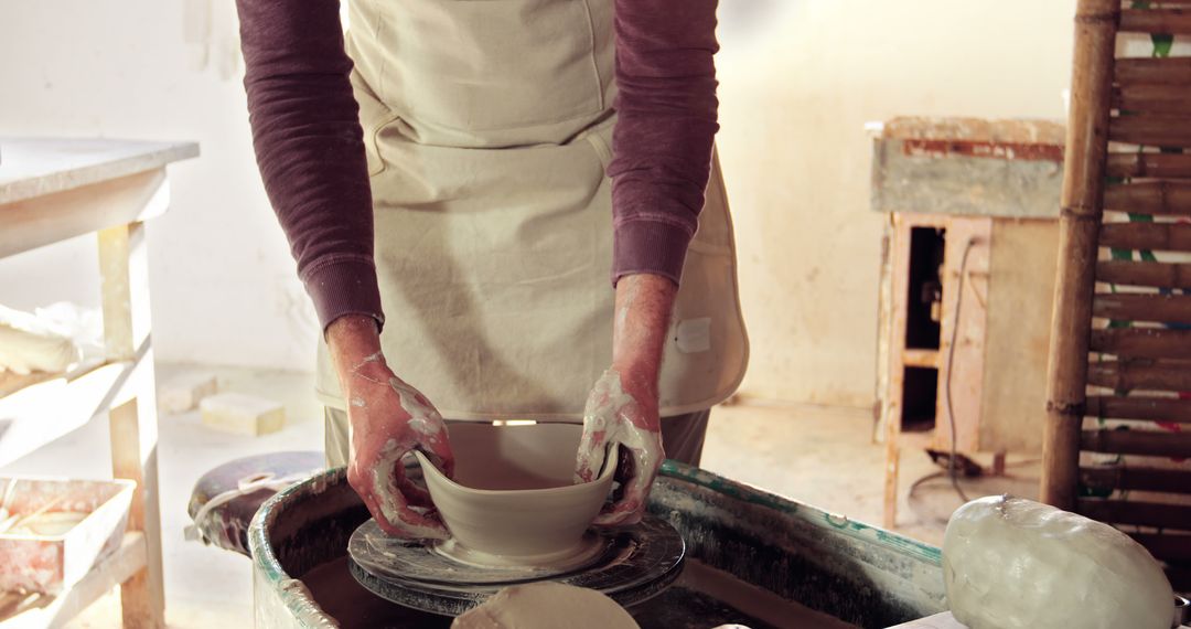 Potter Shaping Clay on Pottery Wheel in Workshop - Free Images, Stock Photos and Pictures on Pikwizard.com