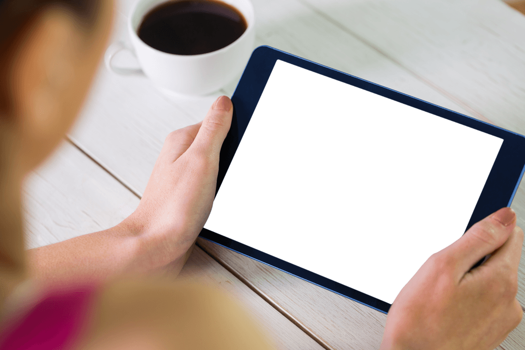Transparent Tablet Held by Hands with Coffee on Table